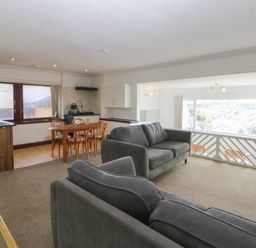 A living room with a sofa and dining area at Seaview in Y Felinheli