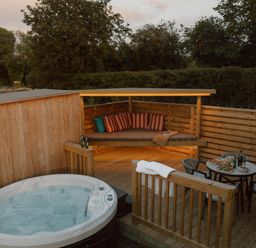 An outdoor seating area with a hot tub at Exclusive Tempest Spa in Grimsby