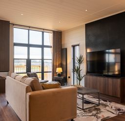 A living room with a TV and a sofa at Exclusive Tempest Spa in Grimsby