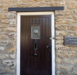 A front door with stone wall at Honeypot Cottage in Weymouth