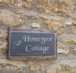 A sign reading Honeypot Cottage on a stone wall at Honeypot Cottage in Weymouth