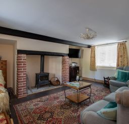 A living room with a fireplace and sofa at Honeypot Cottage in Weymouth