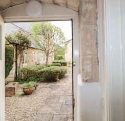 A view from the entrance showing a pathway and greenery at Longfords Mill near Nailsworth