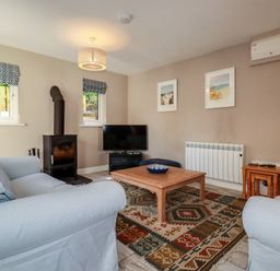 A living room with a television and coffee table at Stowaway Cottage in Padstow