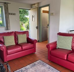 A living room with sofas and a door leading to the kitchen at Wren Cottage in Cowbridge