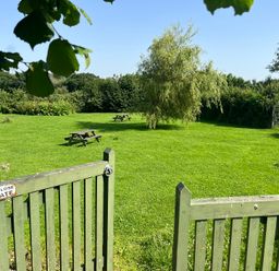 A garden with picnic tables and a gate at Wren Cottage in Cowbridge