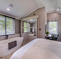 A bedroom featuring a bathtub and a workspace at Prion 1.0 Pet in Llandyrnog