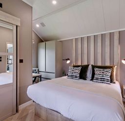 A bedroom with a bed and wardrobe at Prion 1.0 Pet in Llandyrnog