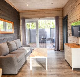 A living room with a sofa, coffee table, and television at Pine Lodge Spa Carlton Miniott near Thirsk