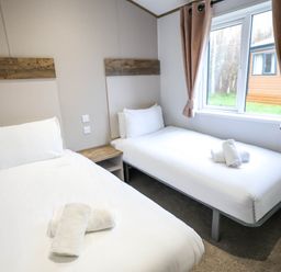 A bedroom with single and twin beds at Laurel Waterside Spa Carlton Miniott near Thirsk