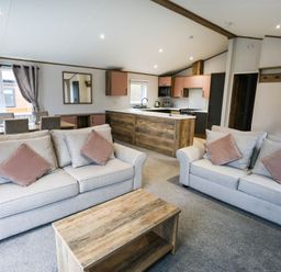 A living room with a sofa and dining area at Laurel Waterside Spa Carlton Miniott near Thirsk
