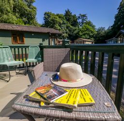 An outdoor seating area with a table, chairs, magazines and a hat at 51 Calgarth Park, Troutbeck