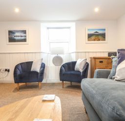 A living room with armchairs and a coffee table at Ty Bryn in Marazion