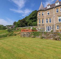 An outdoor area with a lawn and building at Apartment 1, Bryn Mel Manor Menai Bridge