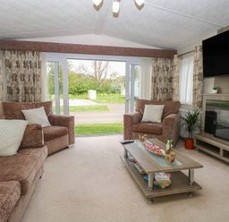 A living room with a sofa and coffee table at The Norfolk Nook 18 Castle Walk Burgh Castle
