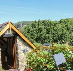 An outdoor area with a door and a chair at The Mill Barn in Lustleigh