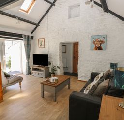 A living room with a sofa and coffee table at Daffodil Cottage in Blaencwm near Treorchy