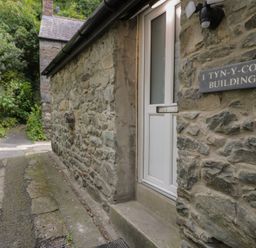 A building entrance with a stone wall and pathway at Llety Cllyd Barmouth