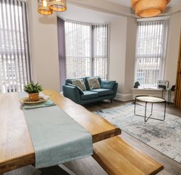 A living room with a dining table, sofa, and coffee table at Llety Cllyd, Barmouth