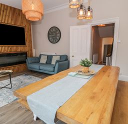 A living room with a sofa and dining table at Llety Cllyd in Barmouth