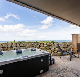 An outdoor area with a hot tub and chairs at tbc in St. Ives