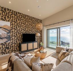 A living room with a sofa and television at Hidden 9 – Grand Bay Suite Hot Tub, St Ive