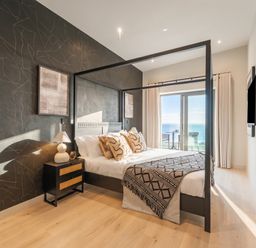 A bedroom with a bed and television at Hidden 9 – Grand Bay Suite Hot Tub St Ive