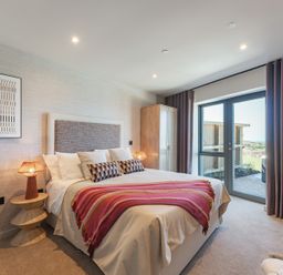 A bedroom with a bed and wardrobe at tbc in St. Ives