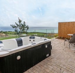 An outdoor area with a hot tub and chair at tbc in St. Ives