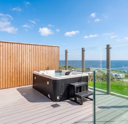 An outdoor area with a hot tub and ocean view at Hidden 19- Coastal Hot Tub St Ives
