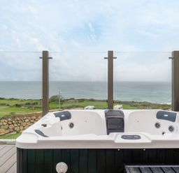 A hot tub with ocean view on a deck at tbc St. Ives