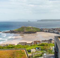 A view of a beach with houses and a hill at Hidden 10- Godrevy View, St Ives