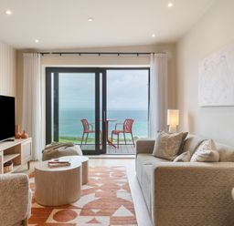 A living room with a sofa and a coffee table at Hidden 10- Godrevy View in St Ives