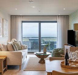 A living room with a sofa and a view of the sea at tbc in St. Ives