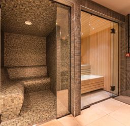 A sauna and steam room with tiled walls at Hidden 14- Garden Terrace in St Ives