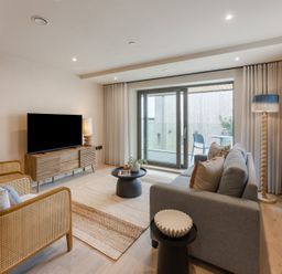 A living room with a television, sofa, and balcony access at tbc in St. Ives