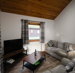 A living room with a sofa and television at Sidlaw in Fowlis near Dundee