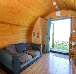 A living room with a sofa and table at Bron Eifion Pod 1 in Criccieth