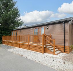 A wooden cabin with a deck and steps at Fox Red Retreat Troutbeck Bridge