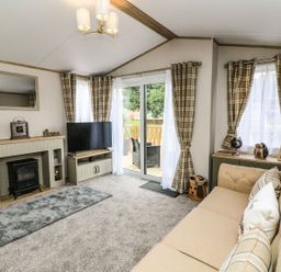 A living room with a television and a sofa at Hedgehog Lodge in Carnforth
