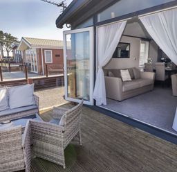 An outdoor area with seating and a view of a living room at Stone Crab Lodge in Haverfordwest