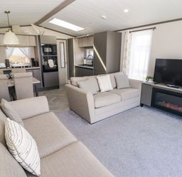 A living room with a sofa and television at Stone Crab Lodge in Haverfordwest