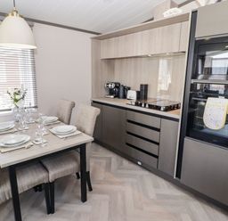 A kitchen with a dining area at Stone Crab Lodge in Haverfordwest