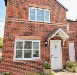 An exterior view of a house with brick walls and a door at 26 Field Court 