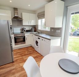 A kitchen with appliances and a dining table at 26 Field Court