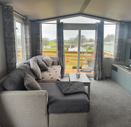 A living room with a sofa and coffee table at Lochwood Platinum Superior at Three Lochs Holiday Park Newton Stewart