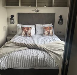 A bedroom with a bed and nightstands at Lochwood Platinum Superior at Three Lochs Holiday Park Newton Stewart