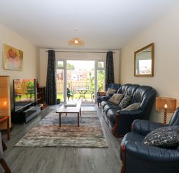 A living room with a television and sofas at The Mill House Gardens 