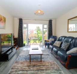 A living room with a sofa and television at The Mill House Gardens