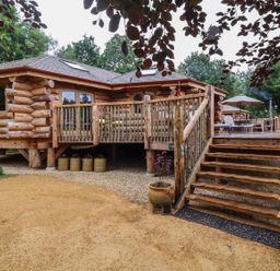 An outdoor area featuring a log cabin with a deck and steps at Copper Suite in Chulmleigh